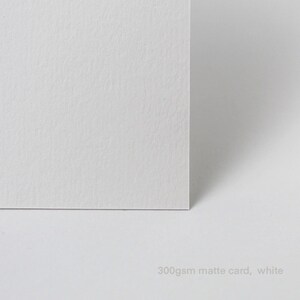 Puede incluir: Primer plano de una tarjeta blanca mate de 300 g/m&sup2;.