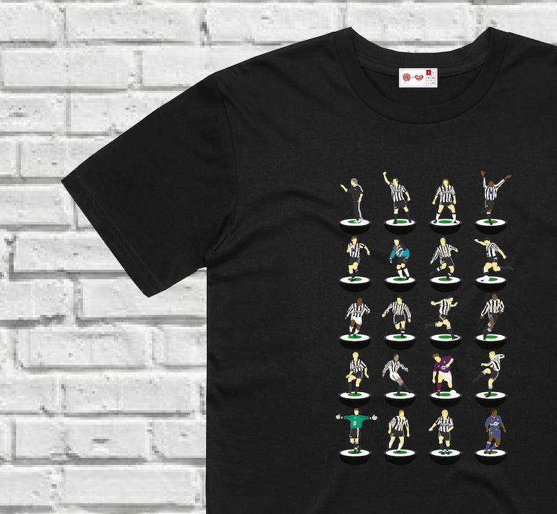 Puede incluir: Camiseta negra con una ilustraci&oacute;n en blanco y negro de un equipo de f&uacute;tbol. La ilustraci&oacute;n muestra 22 jugadores en una formaci&oacute;n de f&uacute;tbol cl&aacute;sica.