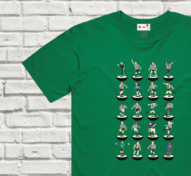 Puede incluir: Una camiseta verde con un dise&ntilde;o de 24 jugadores de f&uacute;tbol con uniformes negros y blancos sobre un fondo blanco. Los jugadores est&aacute;n dispuestos en cuatro filas de seis jugadores cada una. Cada jugador est&aacute; de pie sobre un c&iacute;rculo blanco y negro.