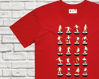 May include: Red t-shirt with a white design of soccer players on a white background. The players are in a formation on a soccer field. The design is a parody of the popular 'Subbuteo' table football game.