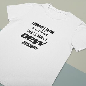 Pode incluir: Camiseta branca com texto preto que diz "Eu sei que tenho um problema, por isso faço terapia de dew!"