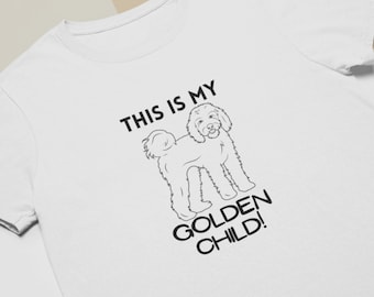 May include: White t-shirt with a black line drawing of a dog and the text "This is my Golden Child!"