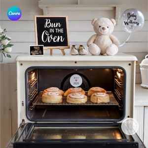 Peut inclure: Un four blanc avec la porte ouverte, révélant une grille de brioches à la cannelle à l'intérieur. Un panneau sur la porte du four indique "Bun in the Oven". Un ours en peluche et un ballon qui dit "Baby Williams" sont sur le dessus du four.