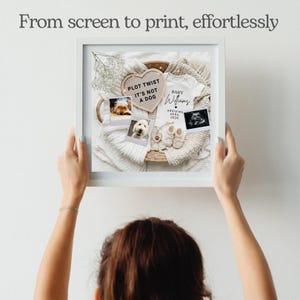 May include: A framed print with a baby announcement theme. The print includes a white onesie, baby shoes, ultrasound image, and photos of dogs. Text on the print reads "Plot Twist It's Not A Dog" and "Baby Williams Arriving April 2026."