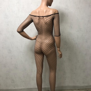 Pu&ograve; includere: Body in rete nera con scollo rotondo e maniche corte. Il body &egrave; realizzato in un materiale elastico e trasparente.