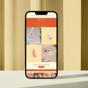 以下が含まれることがあります： スキンケア製品のセールを掲載したウェブサイトが表示されている携帯電話の画面。ウェブサイトには、美容液のボトルとクリームのチューブなど、製品の画像が掲載されています。画面のテキストには、「What's on Sale?」「Hurry these deals won't last!」と表示されています。