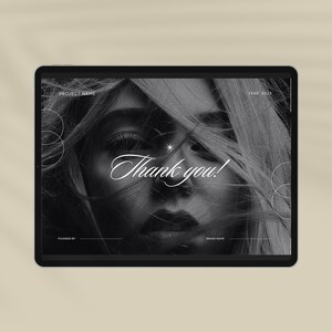 May include: A black and white image of a woman's face with the text "Thank you!" in white cursive font. The image is on a tablet screen with the text "Project Name" and "Year 2023" at the top.