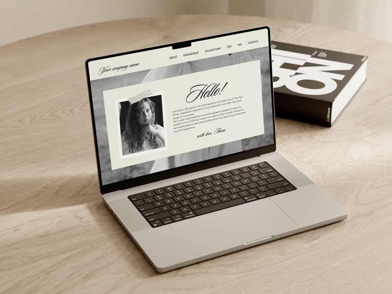 May include: A laptop computer open to a website with the text "Hello!" and a black and white photo of a young girl. The website also includes the text "Your company name" and navigation links for "About", "Engagement", "Collections", "Blog", "FAQ", and "Contact".