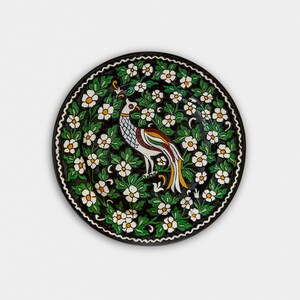 Vintage hand painted green decorative plate with a peacock in the center.
