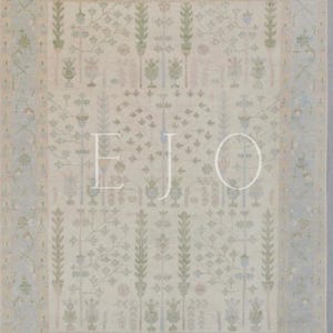 May include: A beige rug with a light blue border and a repeating pattern of stylized plants and flowers. The rug has a subtle, faded look, giving it a vintage feel.