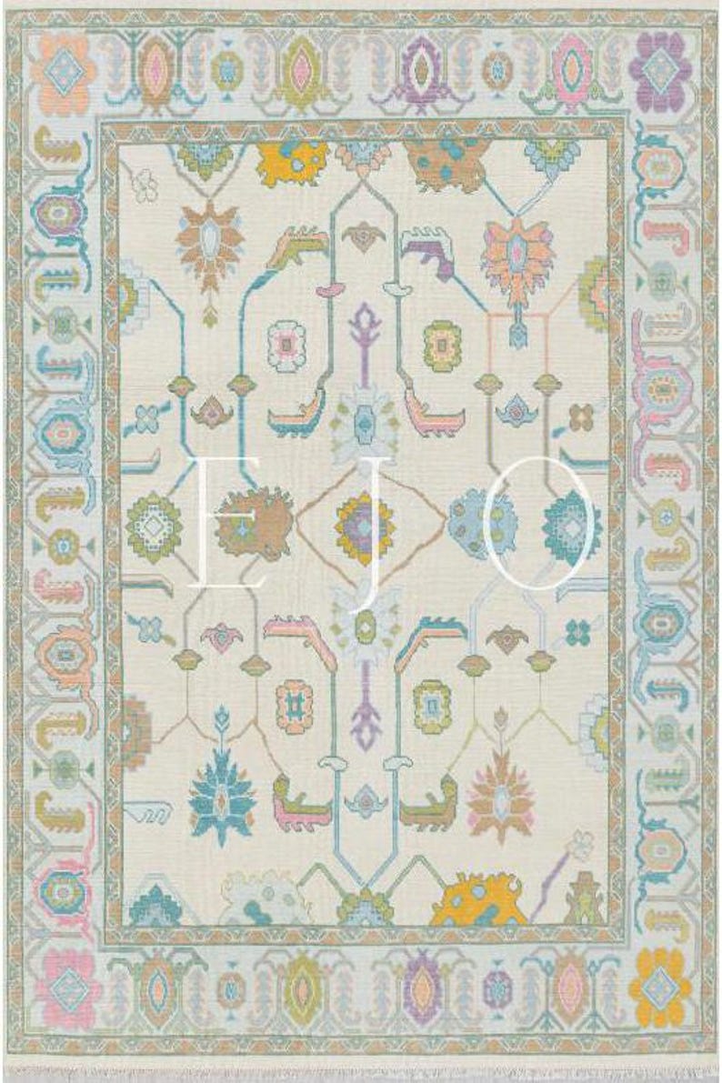 May include: A cream-coloured rug with a repeating pattern of teal, pink and yellow floral designs. The rug has a border with a repeating pattern of teal, pink and yellow geometric shapes.