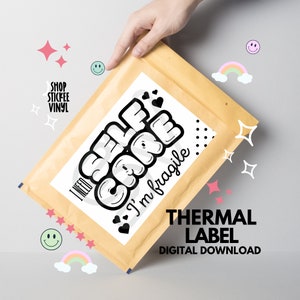May include: A white thermal label with black text that reads "I need self care I'm fragile" with black hearts and polka dots. The label is on a brown envelope.