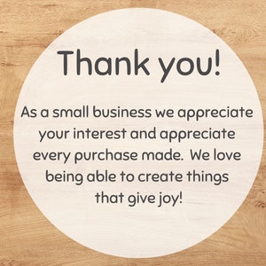 May include: A white circle with a woodgrain background. The circle contains the text "Thank you!" and a message that reads "As a small business we appreciate your interest and appreciate every purchase made. We love being able to create things that give joy!"