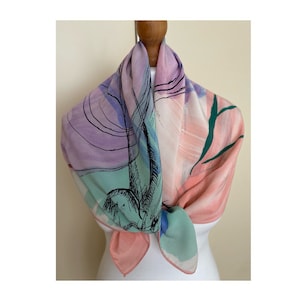 Puede incluir: Una bufanda de seda rosa, verde y morada con un dise&ntilde;o abstracto. La bufanda est&aacute; atada alrededor del cuello de un maniqu&iacute;.