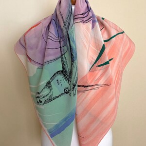 Puede incluir: Un pa&ntilde;uelo de seda cuadrado con un dise&ntilde;o abstracto colorido. El pa&ntilde;uelo presenta un dibujo de un caballo en tinta negra, con lavados de acuarela rosa, verde, azul y morado en el fondo.