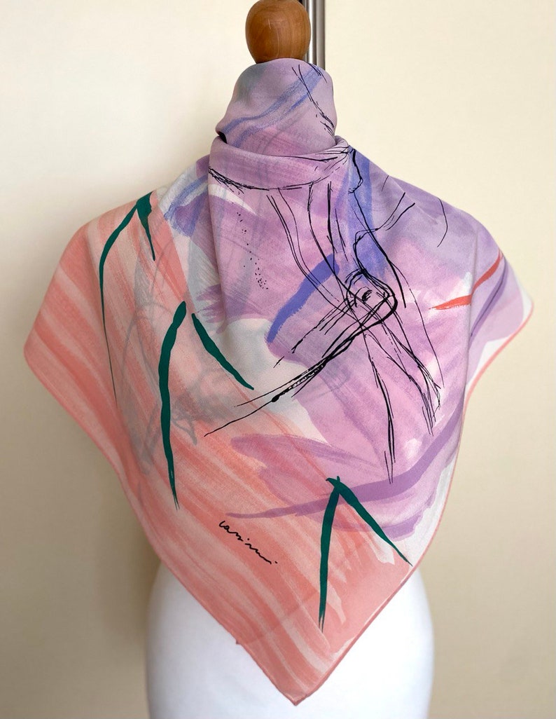 Puede incluir: Un pa&ntilde;uelo de seda con estampado abstracto en rosa, morado y verde con la firma "lamina" en tinta negra.