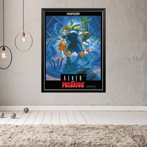 Könnte beinhalten: Ein schwarzer gerahmter Poster mit einer blauen, grünen und roten Illustration eines Charakters aus dem Videospiel "Alien vs Predator". Der Poster trägt den Titel "Alien vs Predator" und das Capcom-Logo.