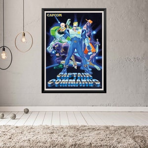 May include: Framed CAPCOM Captain Commando poster. The artwork features a group of futuristic heroes in blue, green, and orange, set against a dark blue background. The title "CAPTAIN COMMANDO" is prominently displayed in a metallic font.