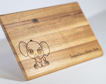 May include: A wooden cutting board with an engraved cartoon elephant and the text "Jaquelines Bärenchen".
