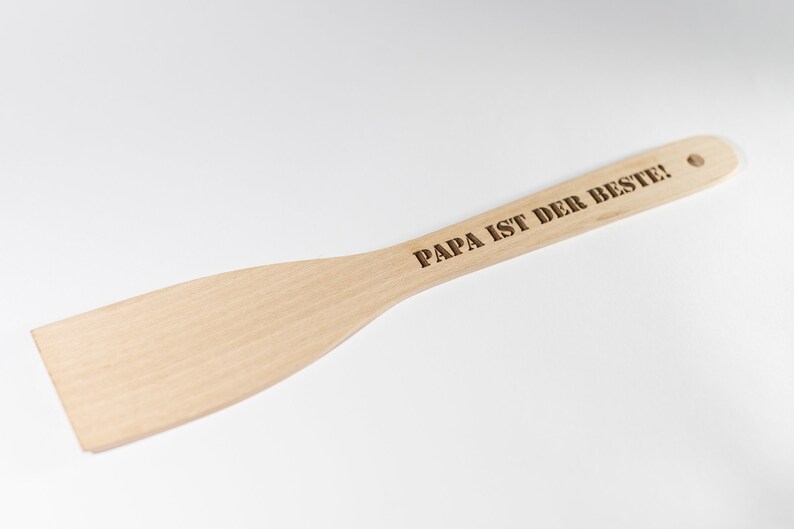 May include: A wooden spatula with the text "PAPA IST DER BESTE!" engraved on the handle.