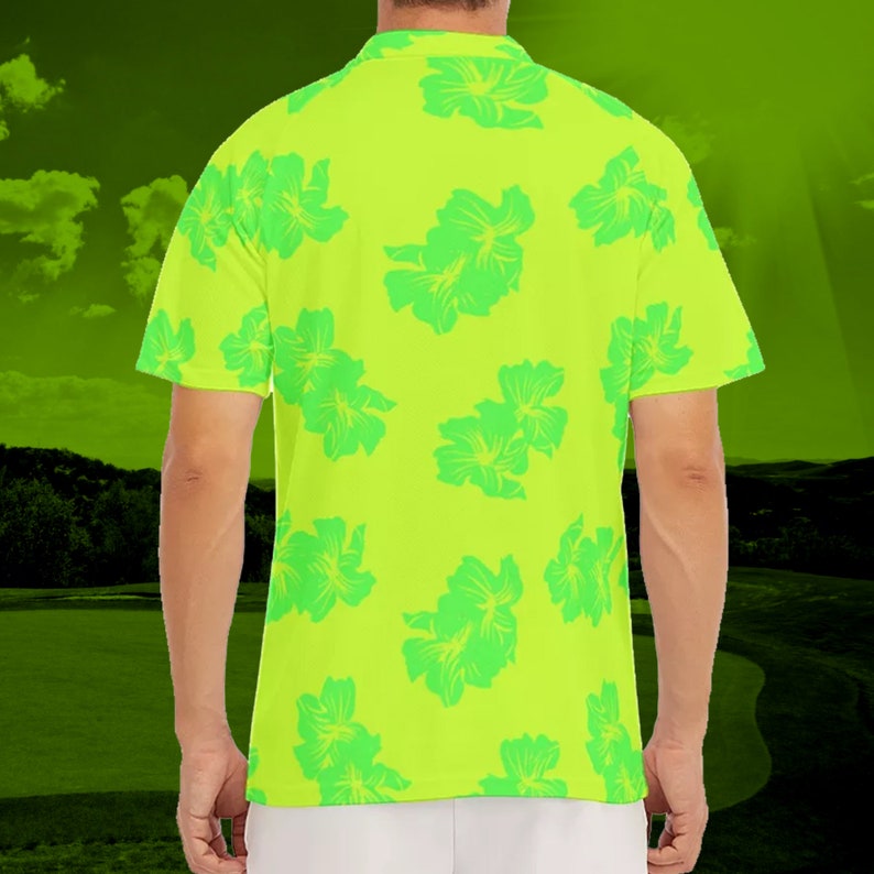 Puede incluir: Una camisa de manga corta de color verde ne&oacute;n con estampado floral tropical. La camisa tiene cuello y cierre de botones.