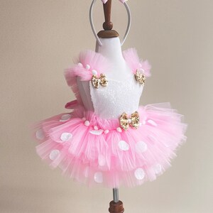a little girl's pink and white dress on a mannequin