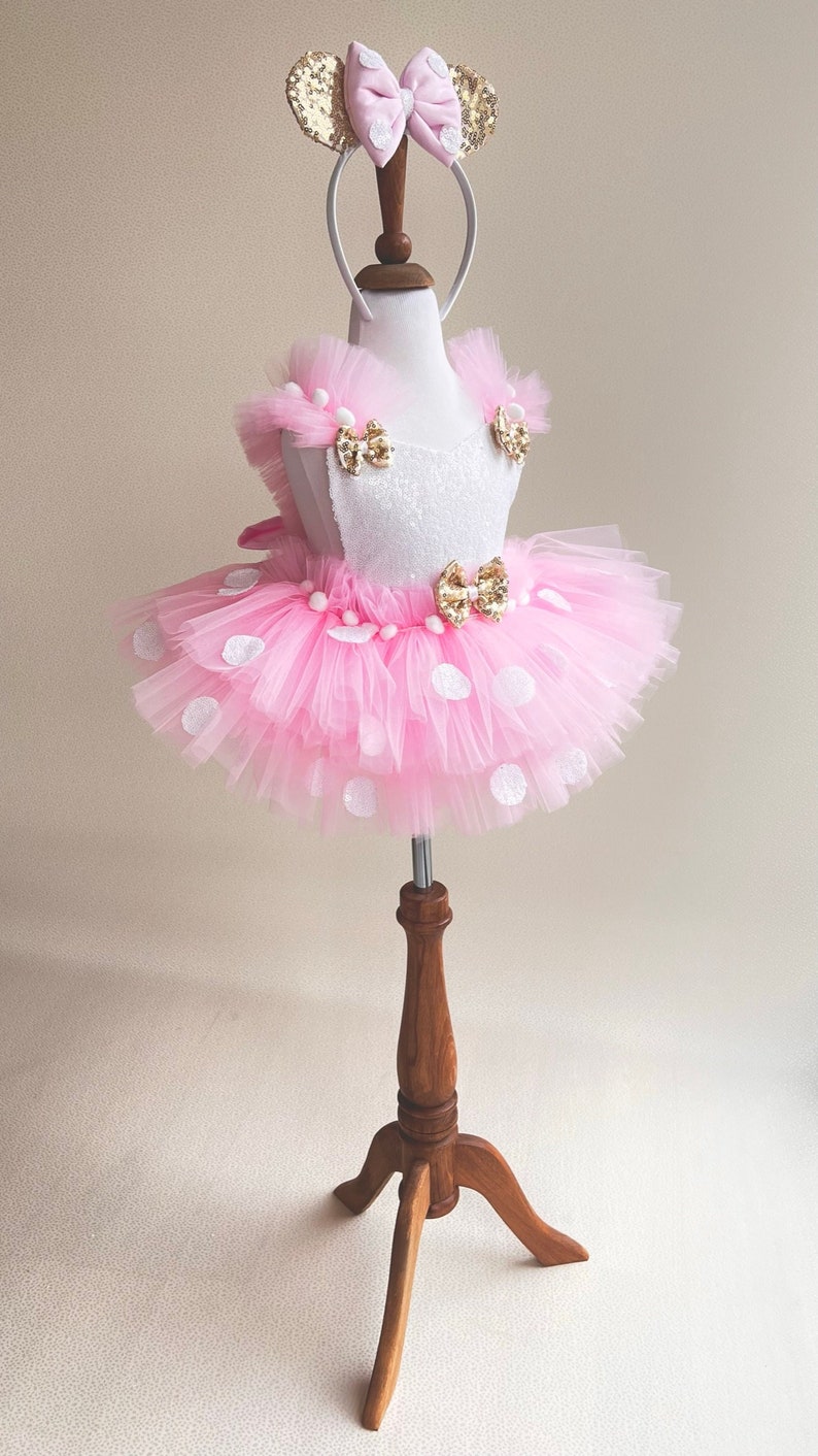 a little girl's pink and white dress on a mannequin