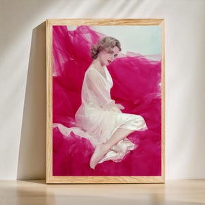 Grace Kelly con vestido de seda color crema con mangas transparentes, sentada sobre tela rosa, retrato de estudio de Hollywood antiguo de los años 50, arte de pared retro y decoración de moda
