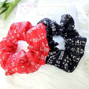 May include: Two fabric hair scrunchies with a white print on a red and black background. The print includes Korean characters and the word "Thank You".