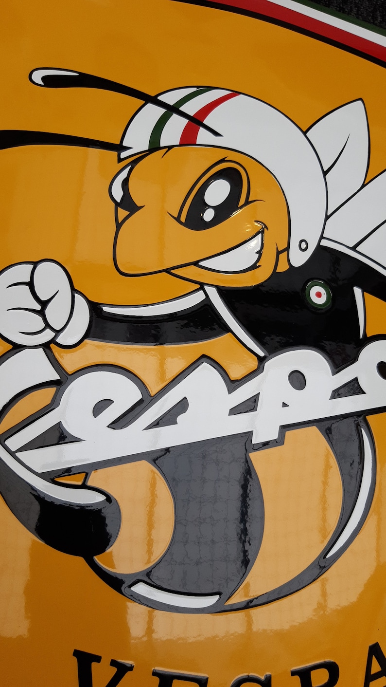 K&ouml;nnte beinhalten: Ein gelbes und schwarzes Vespa-Scooter-Logo mit einer Cartoon-Biene, die einen Helm tr&auml;gt. Die Biene h&auml;lt eine Faust und das Wort "Vespa" ist in wei&szlig;en Buchstaben auf dem Roller geschrieben.