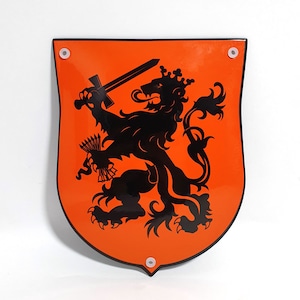 May include: Orange shield-shaped sign with a black lion holding a sword. The lion is standing on its hind legs and has a crown on its head.