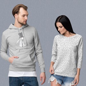 K&ouml;nnte beinhalten: Ein grauer Hoodie mit einem wei&szlig;en Kaninchen, das einen Zylinder und eine Fliege tr&auml;gt, und dem Text "I'm your rabbit". Ein wei&szlig;es Langarmshirt mit einem schwarzen Blumenmuster.