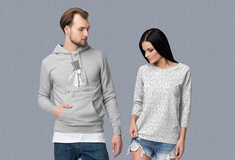 K&ouml;nnte beinhalten: Ein grauer Hoodie mit einem wei&szlig;en Kaninchen, das einen Zylinder und eine Fliege tr&auml;gt, und dem Text "I'm your rabbit". Ein wei&szlig;es Langarmshirt mit einem schwarzen Blumenmuster.