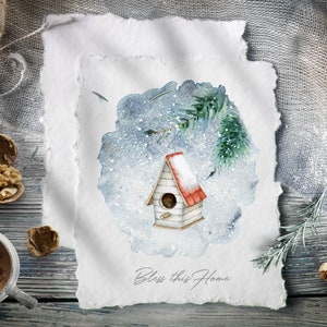 Op de afbeelding: Een aquarel schilderij van een vogelhuisje met een rood dak, omringd door een besneeuwde blauwe achtergrond. Het vogelhuisje staat op een tak van een dennenboom. De tekst "Bless this Home" staat onder het vogelhuisje.
