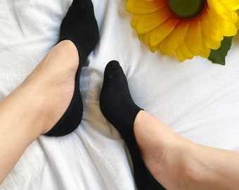May include: A pair of black no-show socks on a white background. The socks are made of a soft, breathable fabric and are designed to be worn with low-cut shoes.