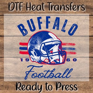 May include: DTF Heat Transfers graphic featuring a distressed blue and red football helmet with the word "BUFFALO" above it. Below the helmet are the words "Football" and "Ready to Press". The year "1960" is also included.