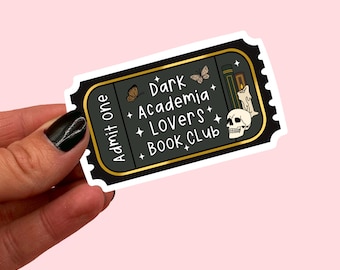 May include: A black and gold sticker with the text "Dark Academia Lovers Book Club" and illustrations of a skull, books, a candle, and butterflies.