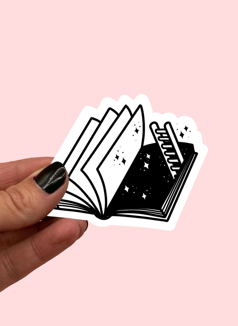 May include: A black and white sticker of an open book with a starry night sky inside. A ladder leads up to the stars. The sticker is on a pink background.