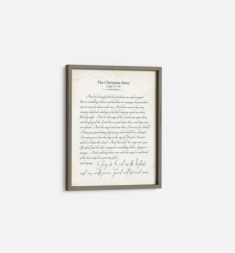 May include: A framed print with a beige background and black text. The text is a passage from the Bible, Luke 2:7-14, telling the story of the birth of Jesus. The title of the print is "The Christmas Story".