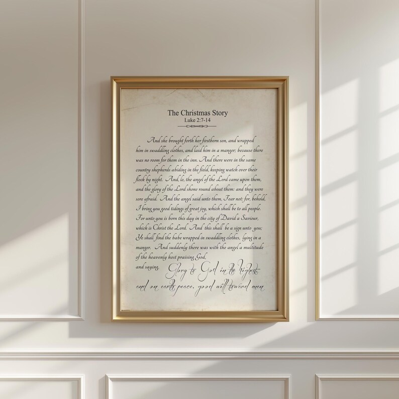 May include: A vintage-style print with a gold frame featuring a black and white text excerpt from the Bible, Luke 2:7-14, about the Christmas story. The text reads "The Christmas Story" and includes the verse "And she brought forth her firstborn son, and wrapped him in swaddling clothes, and laid him in a manger, because there was no room for them in the inn." The text continues with the story of the shepherds and the angel's announcement of the birth of Jesus.