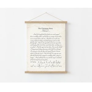 May include: A vintage-style print with a beige background and black text. The print features a passage from the Bible, Luke 2:7-14, telling the story of the birth of Jesus. The text reads "The Christmas Story" and "And she brought forth her firstborn son, and wrapped him in swaddling clothes, and laid him in a manger, because there was no room for them in the inn. And there were in the same country shepherds abiding in the field keeping watch over their flock by night. And, lo, the angel of the Lord came upon them, and the glory of the Lord shone round about them: and they were sore afraid. And the angel said unto them, Fear not: for, behold, I bring you good tidings of great joy, which shall be to all people. For unto you is born this day in the city of David a Saviour, which is Christ the Lord. And this shall be a sign unto you: Ye shall find the babe wrapped in swaddling clothes, lying in a manger. And suddenly there was with the angel a multitude of the heavenly host praising God, and saying, Glory to God in the highest, and on earth peace, good will toward men."