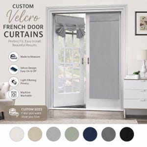 Puede incluir: Cortinas de tela gris claro para puertas francesas con sistema de fijación de velcro. Una cortina está extendida, mientras que la otra está recogida en la parte superior con lazos de tela. El texto incluye CUSTOM VELCRO FRENCH DOOR CURTAINS.