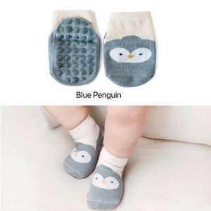 Puede incluir: Un par de calcetines para beb&eacute; con un dise&ntilde;o de ping&uuml;ino azul. Los calcetines tienen puntos antideslizantes en la parte inferior para ayudar a prevenir resbalones.