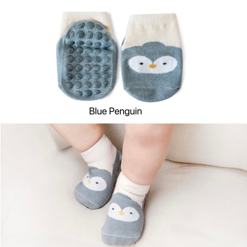 Puede incluir: Un par de calcetines para beb&eacute; con un dise&ntilde;o de ping&uuml;ino azul. Los calcetines tienen puntos antideslizantes en la parte inferior para ayudar a prevenir resbalones.
