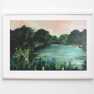 May include: A framed landscape painting depicts a serene lake scene. Lush green trees surround the turquoise water, with a small building visible in the distance. The sky transitions from pink to a soft blue, creating a tranquil atmosphere.