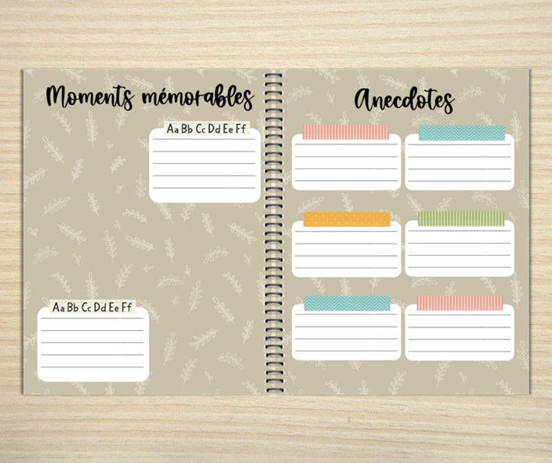 K&ouml;nnte beinhalten: Offenes Notizbuch mit Spiralbindung, mit den W&ouml;rtern "Moments m&eacute;morables" und "Anecdotes". Die Seiten haben linierte K&auml;stchen mit dekorativem Klebeband und einen hellbeigen Hintergrund mit einem Bl&auml;ttermuster. Enth&auml;lt das Alphabet.