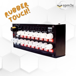 Può includere: Un sequencer Korg SQ-1 nero con una fila di 16 pulsanti rossi e pad in gomma bianca. Il testo "KORG SQ-1" è stampato sulla parte anteriore del sequencer.