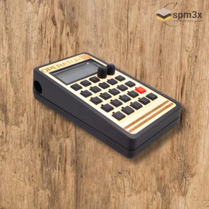 May include: A black and gold drum machine with a red button and a digital display that reads "OPERATOR".