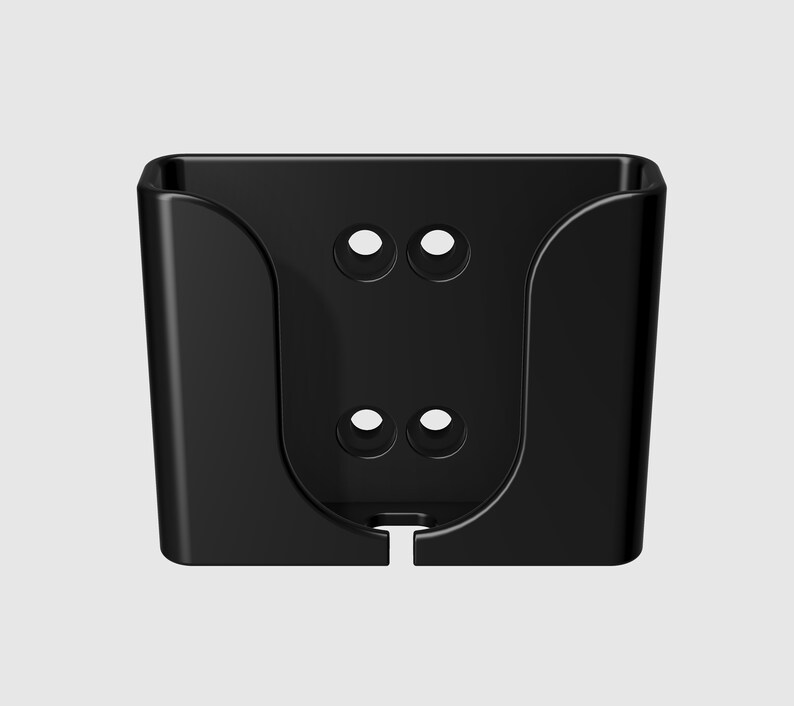 May include: Black plastic wall mount with two sets of holes for mounting screws. The mount has a curved shape to hold a device.