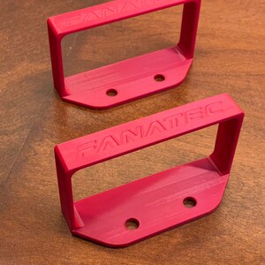 May include: Two red plastic Fanatec mounting brackets with three holes each.